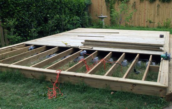 Deck construction shows the deck with half covered decking and support beams underneath.